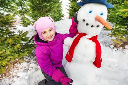 Photo 1: a girl building a snowman in a snowy park