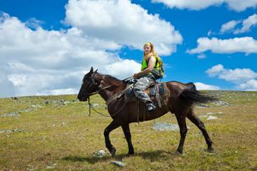 Photo 1: a girl riding a horse in the countryside