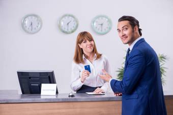 Photo 1 · A hotel receptionist talking to a guest