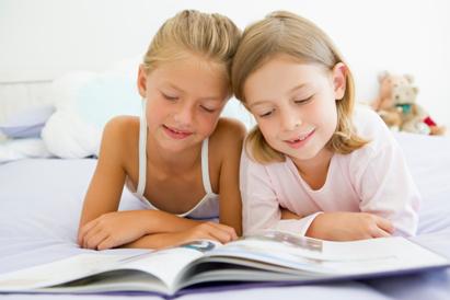 Photo 1 · Deux filles lisent ensemble un livre à la maison.